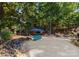 Private beach area with Adirondack chairs and shade umbrella overlooking lush trees at 18420 Rosapenny Rd, Charlotte, NC 28278