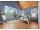 Cozy bedroom with a wood-paneled ceiling, bright windows with lots of natural light, and plush furniture at 18420 Rosapenny Rd, Charlotte, NC 28278