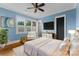 Stylish bedroom with large windows, plantation shutters, neutral decor, and modern TV at 18420 Rosapenny Rd, Charlotte, NC 28278