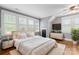 Bright bedroom with hardwood floors, many windows with white shutters, and a comfortable bed with plush pillows at 18420 Rosapenny Rd, Charlotte, NC 28278