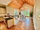 Bright dining area with a table, chairs, and views overlooking the trees with a unique antler chandelier and wood ceiling at 18420 Rosapenny Rd, Charlotte, NC 28278
