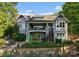 Stately exterior showcasing multi-level decks, stone accents, manicured landscaping, and a fenced-in yard on a sunny day at 18420 Rosapenny Rd, Charlotte, NC 28278