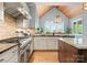 Gourmet kitchen with pro-grade gas range, expansive countertops, and brick backsplash at 18420 Rosapenny Rd, Charlotte, NC 28278