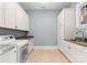 Bright laundry room features ample storage, countertops, and modern washer and dryer units at 18420 Rosapenny Rd, Charlotte, NC 28278