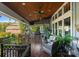 Expansive covered porch featuring a built-in grill, ceiling fans, and comfortable seating, perfect for outdoor entertaining at 18420 Rosapenny Rd, Charlotte, NC 28278