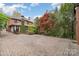 Brick home featuring mature landscaping and a large brick driveway at 2120 Malvern Rd, Charlotte, NC 28207