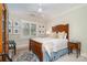 Bright bedroom with a vintage wood bed, accent rug, and a window with views of the outdoors at 2120 Malvern Rd, Charlotte, NC 28207