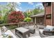 Wooden deck featuring wicker furniture, a glass coffee table, and a view of the wooded backyard at 2120 Malvern Rd, Charlotte, NC 28207