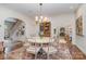 Dining room featuring a decorative rug, chandelier, and access to a living space with a stone fireplace at 2120 Malvern Rd, Charlotte, NC 28207