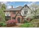 Charming Tudor-style home with brick facade, detailed woodwork, and lush landscaping at 2120 Malvern Rd, Charlotte, NC 28207