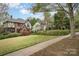 Well maintained front yard of Tudor-style brick home featuring beautiful mature landscaping at 2120 Malvern Rd, Charlotte, NC 28207