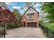 A charming brick carriage house features a two-car garage and landscaped surroundings at 2120 Malvern Rd, Charlotte, NC 28207