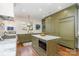 Gourmet kitchen boasts custom olive cabinetry, an island with marble countertop, and stainless steel appliances at 2120 Malvern Rd, Charlotte, NC 28207