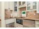 Cozy kitchenette features stainless steel appliances, stylish backsplash, and custom cabinetry at 2120 Malvern Rd, Charlotte, NC 28207