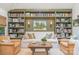 Bright living room showcases custom built-in shelving, a cozy sofa, and leather chairs with a rustic coffee table at 2120 Malvern Rd, Charlotte, NC 28207
