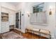 Mudroom boasts custom shelving, drawers, and a window seat by an exterior door and hardwood flooring at 2120 Malvern Rd, Charlotte, NC 28207