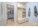 Entryway with custom built-ins and bench leading to another bathroom and neutral walls at 2120 Malvern Rd, Charlotte, NC 28207