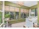 Bright sunroom with multiple windows, neutral furniture, and cozy wicker accents at 2120 Malvern Rd, Charlotte, NC 28207