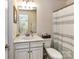 A clean bathroom with a classic vanity, large mirror, and shower with a striped curtain at 2240 Kensington Station Pkwy, Charlotte, NC 28210