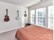 This sunlit bedroom boasts large windows and features guitars and instruments on the wall at 2240 Kensington Station Pkwy, Charlotte, NC 28210