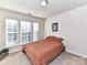 A bright bedroom showcases two large windows with natural light and neutral earth tone bedding at 2240 Kensington Station Pkwy, Charlotte, NC 28210