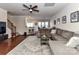 Open-concept living room with hardwood floors, a large sectional sofa, and a ceiling fan at 2240 Kensington Station Pkwy, Charlotte, NC 28210