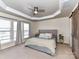 Spacious main bedroom with tray ceiling, ceiling fan, and barn door to bathroom at 2240 Kensington Station Pkwy, Charlotte, NC 28210