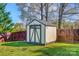 Close-up of shed in the backyard with green and white trim and a privacy fence at 2243 Flint Glenn Ln, Charlotte, NC 28262