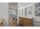 Well-lit bathroom boasts a modern vanity with marble countertop and sleek black fixtures, with a view into the bedroom at 230 S Tryon St # 610, Charlotte, NC 28202