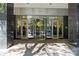 Building entrance featuring revolving doors and glass panels with brick pavers at 230 S Tryon St # 610, Charlotte, NC 28202