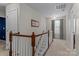 Bright hallway featuring a staircase with white spindles and natural light from a window with decorative curtains at 270 Almora Loop, Mooresville, NC 28115