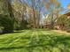 Lush green backyard with meticulously striped lawn, bordered by mature trees and landscaping at 3600 Castellaine Dr, Charlotte, NC 28226