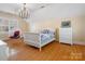 Light and airy bedroom featuring hardwood floors, a hanging chair, and ample natural light at 3600 Castellaine Dr, Charlotte, NC 28226