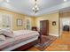 Inviting bedroom features hardwood floors, neutral walls, and a decorative ceiling medallion with an elegant chandelier at 3600 Castellaine Dr, Charlotte, NC 28226