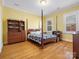 Cozy bedroom with a four-poster bed, hardwood floors, and two windows at 3600 Castellaine Dr, Charlotte, NC 28226