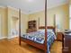 Bedroom featuring a four-poster bed, wood floors, and en-suite bathroom at 3600 Castellaine Dr, Charlotte, NC 28226