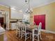 Classic dining room features a decorative light fixture, wood floors, and white trim, with an adjacent kitchen view at 3600 Castellaine Dr, Charlotte, NC 28226