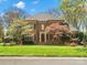 Beautiful two-story brick home with manicured lawn and mature trees at 3600 Castellaine Dr, Charlotte, NC 28226