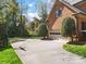 Home exterior featuring a garage, basketball hoop, driveway, and green landscaping at 3600 Castellaine Dr, Charlotte, NC 28226