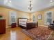 Tranquil main bedroom with natural light, wood floors, a decorative rug, and classic neutral decor at 3600 Castellaine Dr, Charlotte, NC 28226