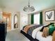 Modern bedroom features a stylish chandelier, framed art, and bright green curtains, creating a serene and inviting space at 3918 Dahlia Dr # 15, Harrisburg, NC 28075