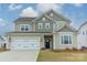 Charming two-story home displaying a well-kept lawn and attached two-car garage at 3918 Dahlia Dr # 15, Harrisburg, NC 28075