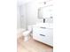 Modern bathroom featuring a floating vanity, rectangular mirror, and toilet with white marble styled tile in the shower at 411 Cemetery St, Charlotte, NC 28216