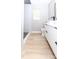 Elegant bathroom showcasing a modern vanity, black hardware, walk-in shower with white marble tile and wood-look floors at 411 Cemetery St, Charlotte, NC 28216