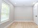 Spacious bedroom with wood-look flooring, a large window, and neutral paint, providing a serene and inviting atmosphere at 411 Cemetery St, Charlotte, NC 28216