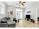 A bright living room with wood flooring, a comfortable gray sofa, and a modern ceiling fan at 474 New Bern Station Ct, Charlotte, NC 28209