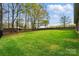 Large backyard featuring a dark metal fence and a brick fence in the background at 5032 Eagles Crest Ln, Gastonia, NC 28056