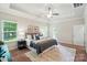 This main bedroom features a tray ceiling, neutral walls, a ceiling fan, and lots of natural light at 5032 Eagles Crest Ln, Gastonia, NC 28056