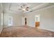 Spacious main bedroom with tray ceiling, fan, carpet floors, and ensuite bath at 5032 Eagles Crest Ln, Gastonia, NC 28056