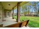 Covered porch with brick columns and wood porch swing overlooking a backyard at 5032 Eagles Crest Ln, Gastonia, NC 28056